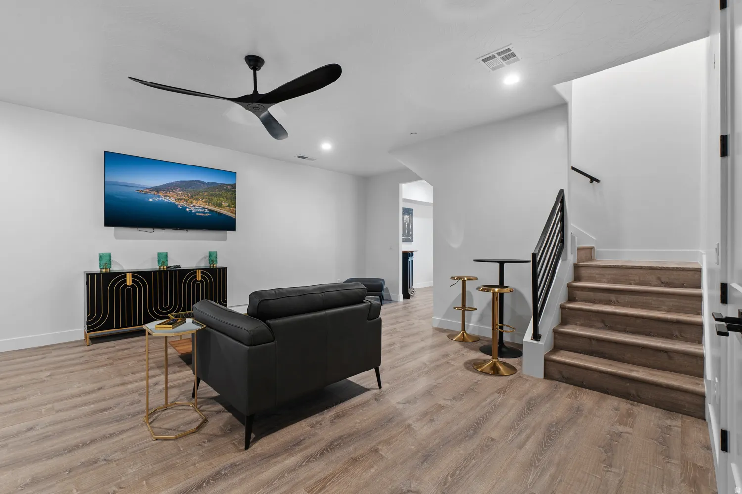 Living area featuring wood-finish flooring, a contemporary ceiling fan, recessed lighting, and a built-in entertainment console
