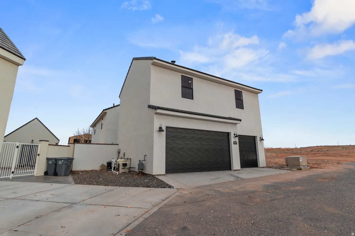 Contemporary stucco exterior featuring a two-car garage, a single-car garage, and black garage doors