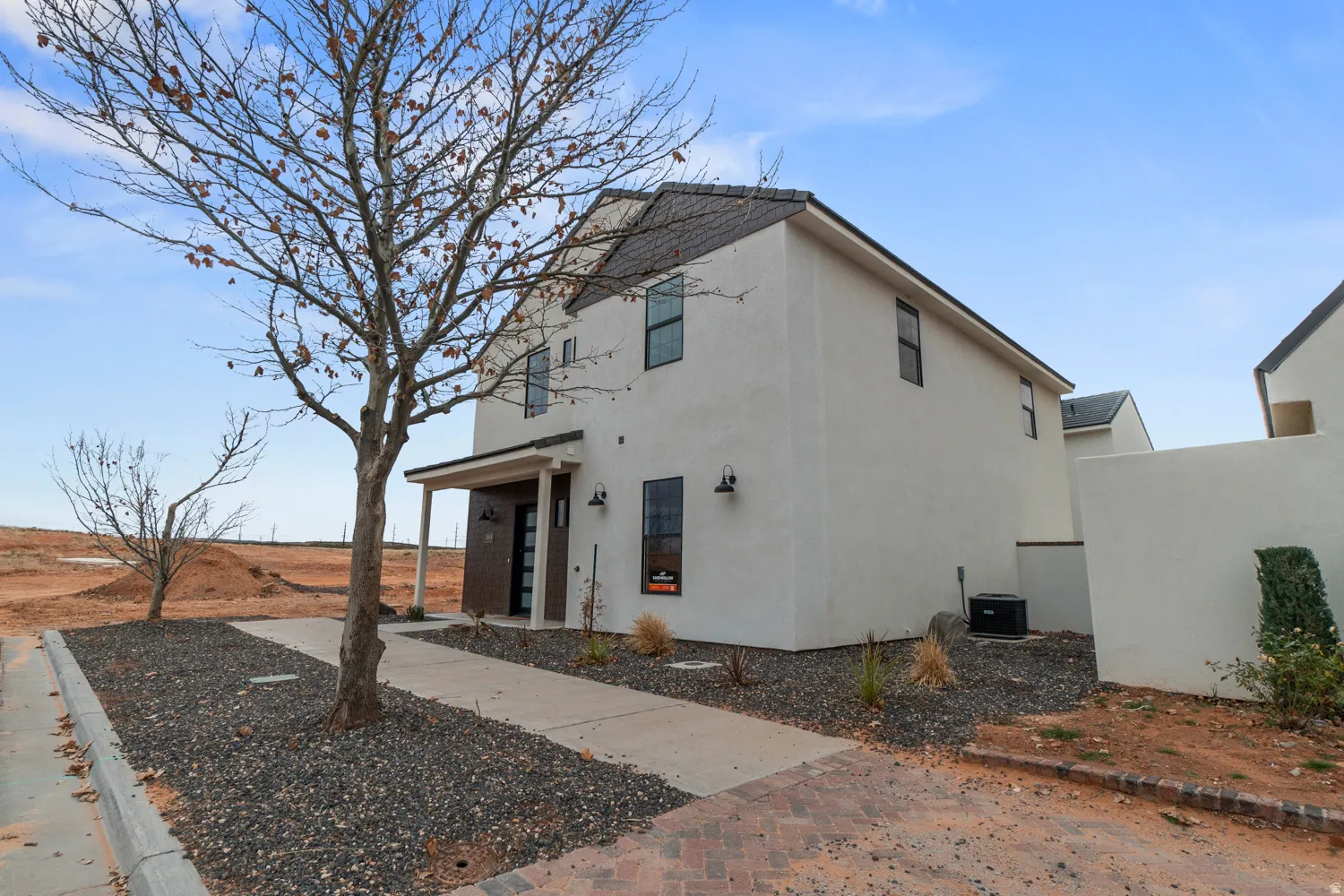 Contemporary two-story residence featuring a smooth stucco exterior with dark trim accents