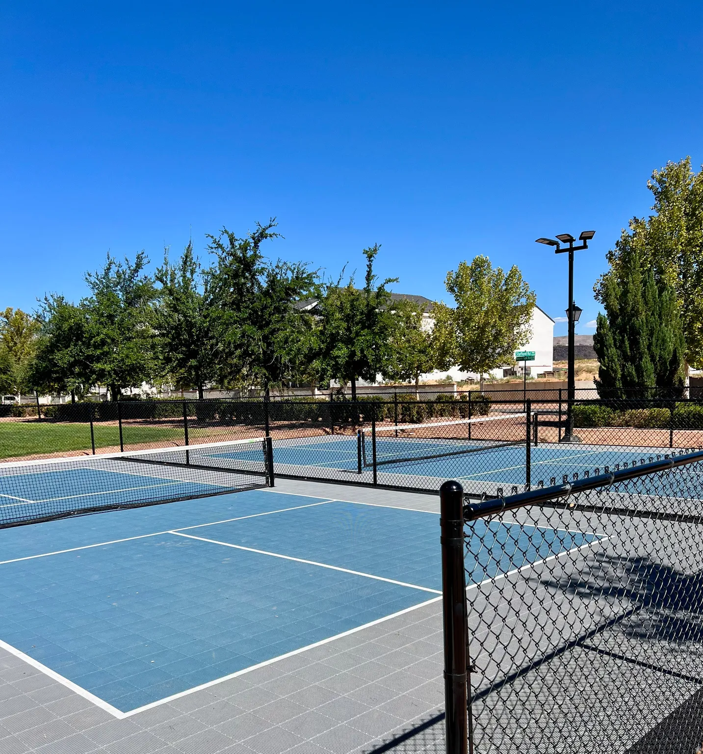 Multiple pickleball courts featuring blue playing surfaces with white boundary lines