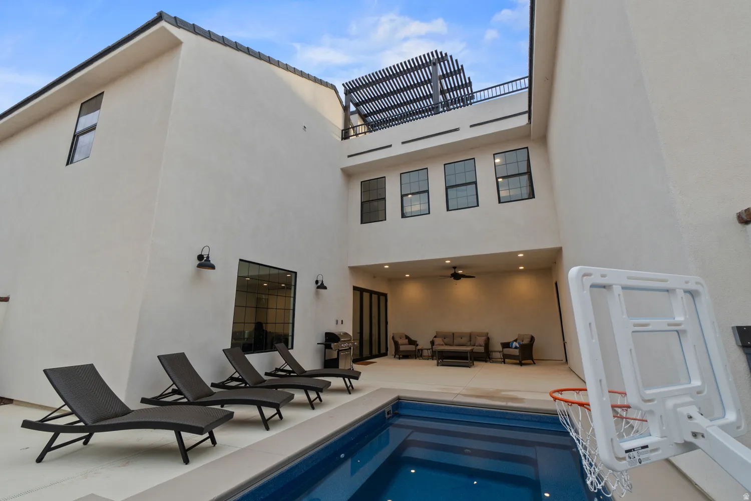 Contemporary stucco exterior featuring a private swimming pool