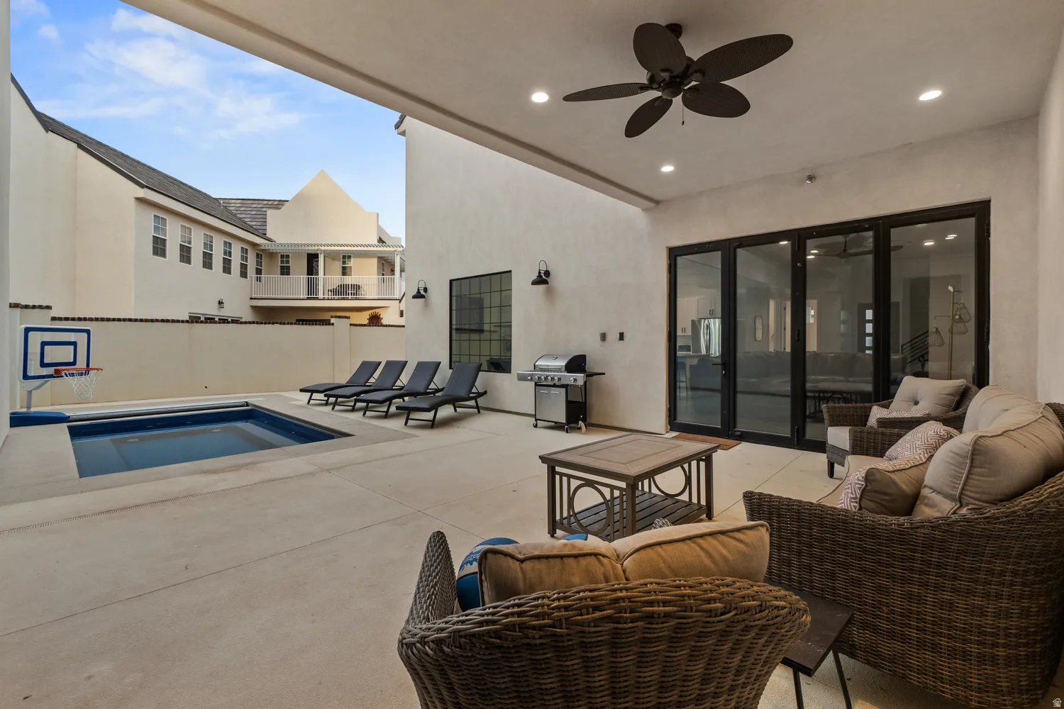 Expansive outdoor patio featuring an integrated swimming pool and a covered lounge area