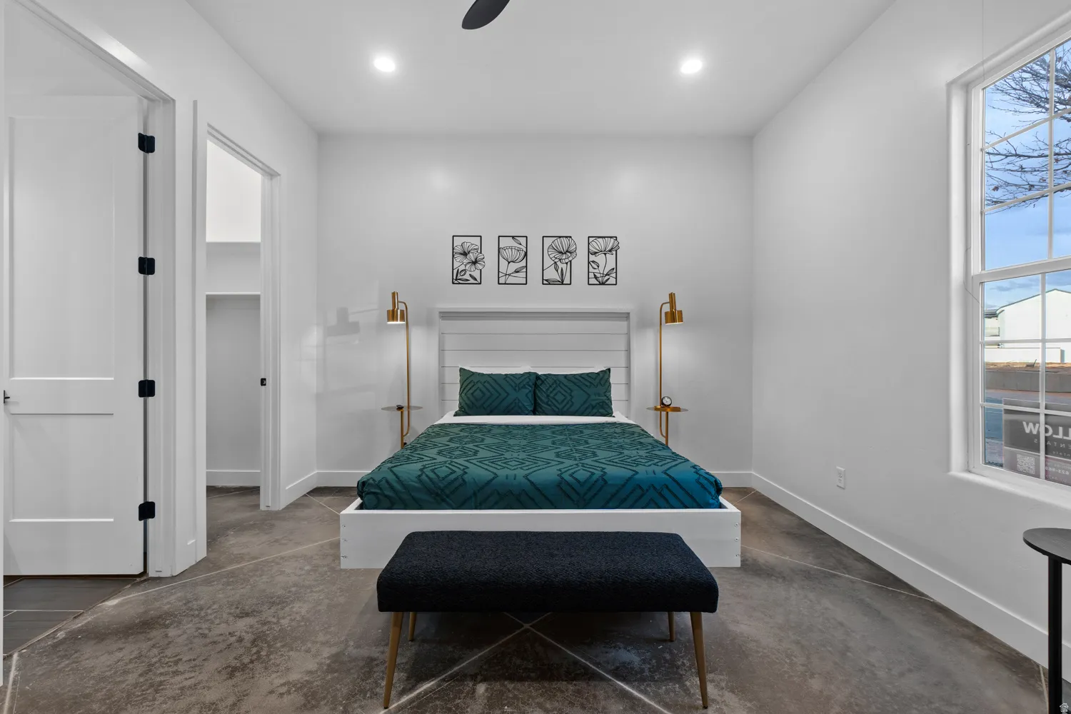 Room with concrete flooring, high ceilings, recessed lighting, and a prominent window