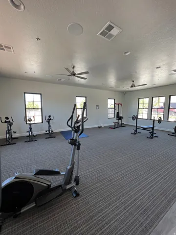 Spacious fitness area featuring carpeted flooring and multiple exercise stations