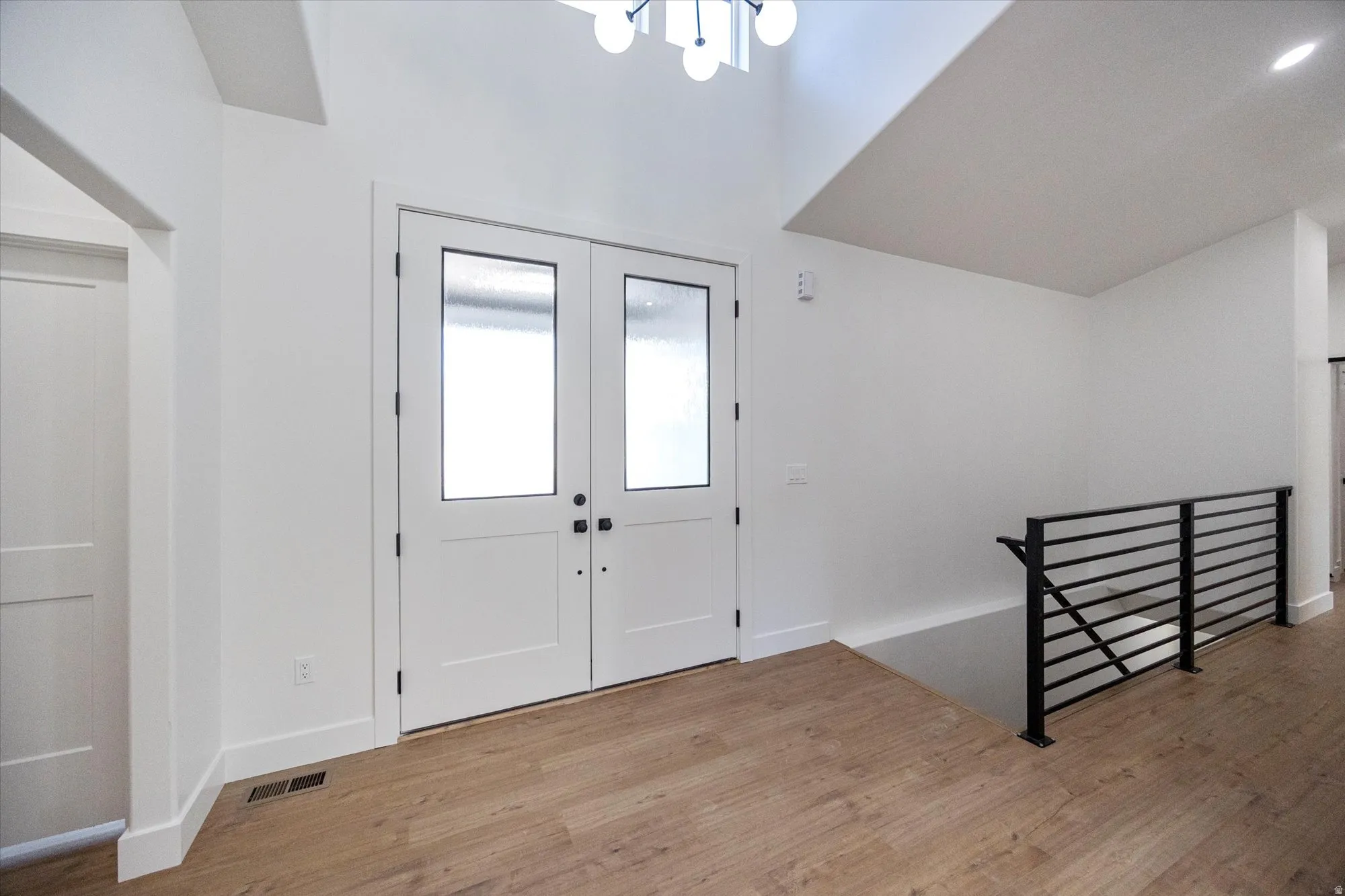 Entryway featuring double doors with frosted glass panels and matte black hardware