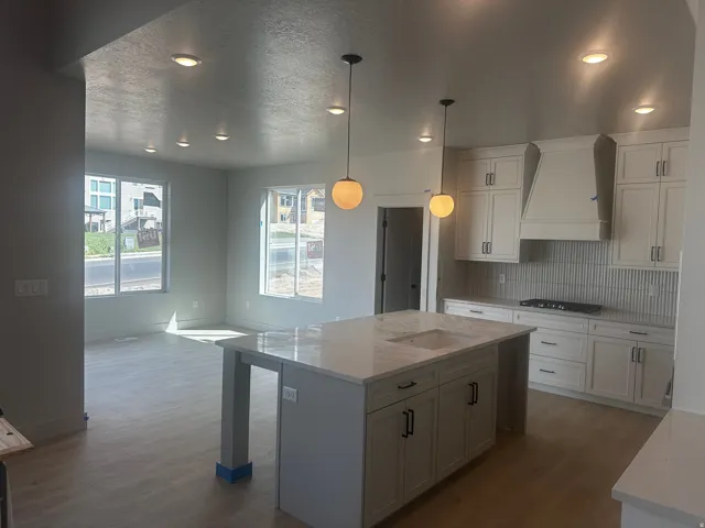 Open-concept living area featuring wood-finish flooring, recessed lighting, and large windows