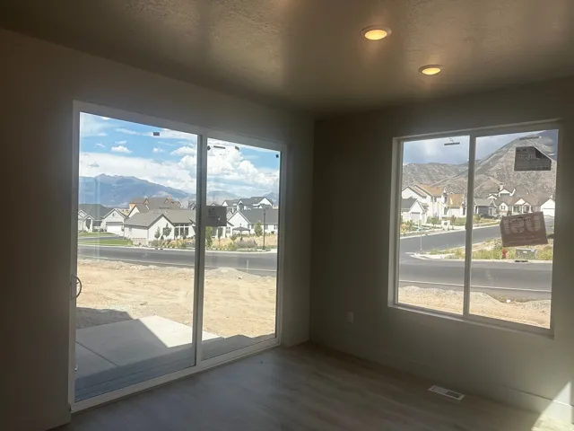 Recessed ceiling lighting, wood-finish flooring, sliding glass door, fixed pane window, and concrete patio