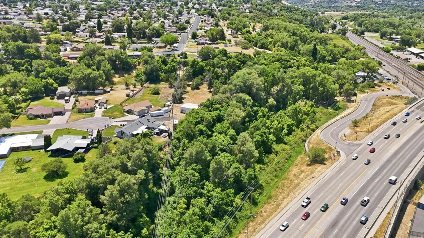 Expansive property parcel featuring significant tree coverage and a paved surface area