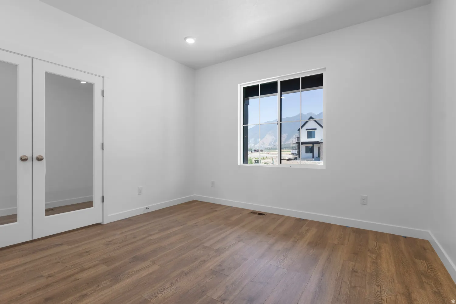 Bright interior space featuring wood-finish flooring, recessed lighting, and a dual-pane window