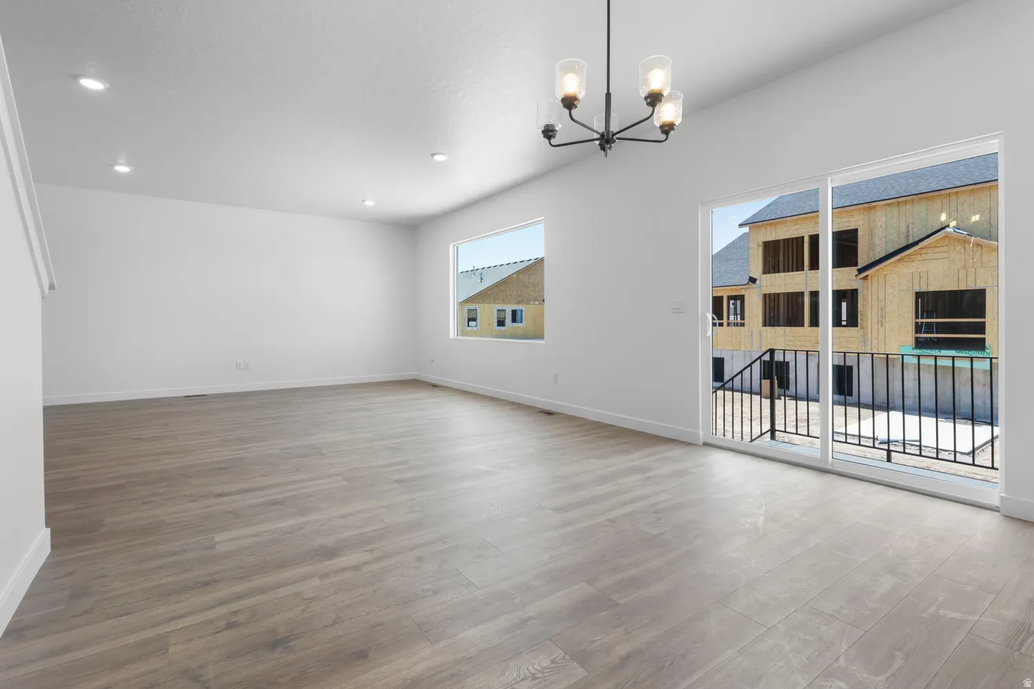Spacious interior featuring wood-finish flooring, recessed lighting, and a modern chandelier