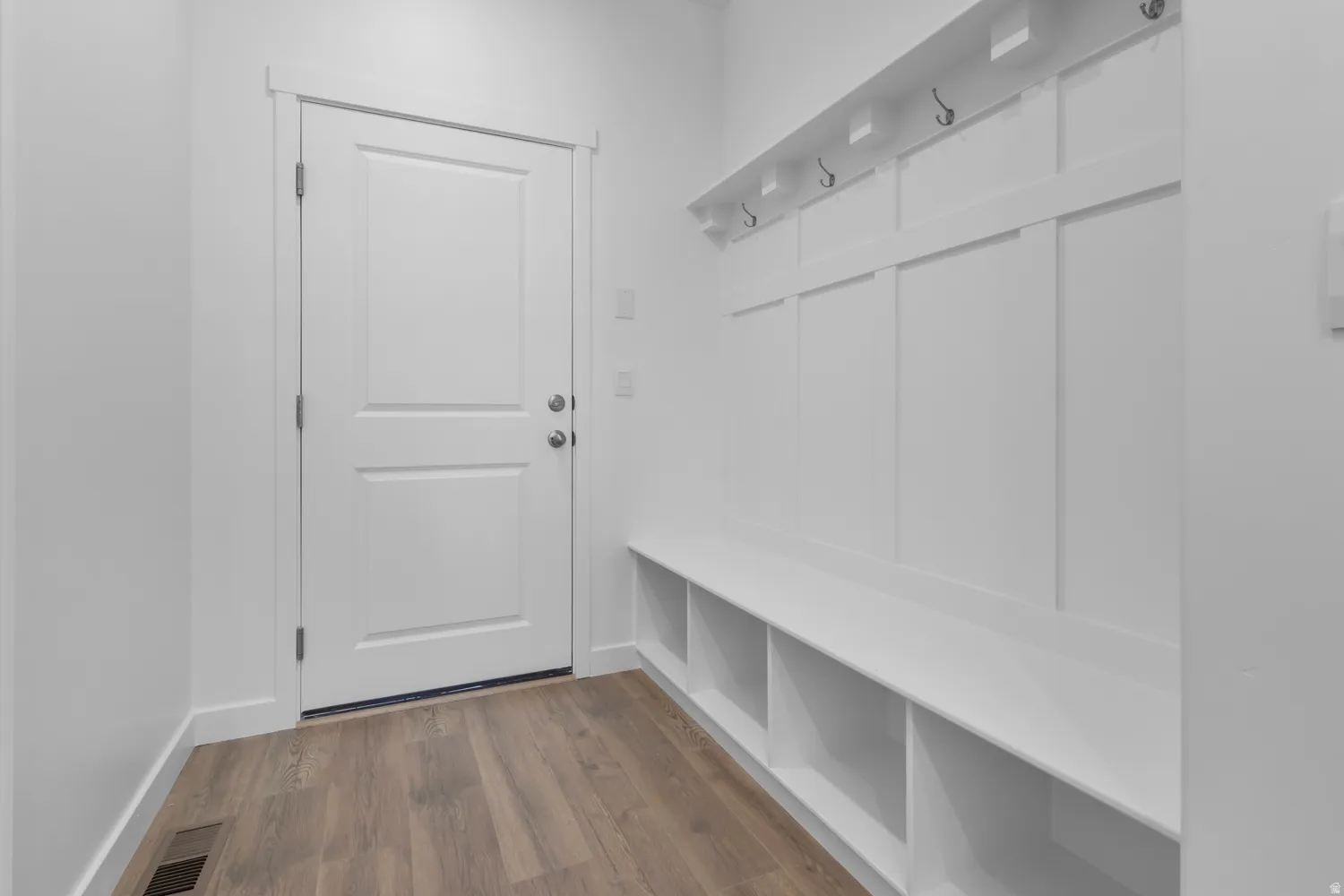 Entryway featuring wood-finish flooring and a white paneled door