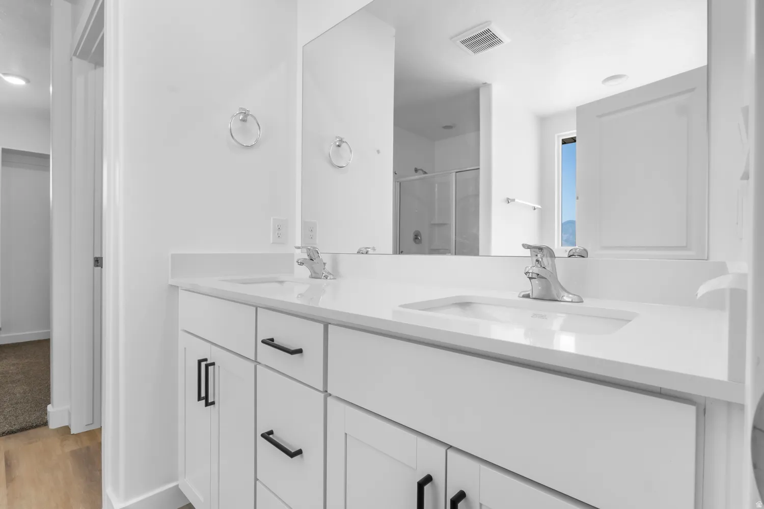 Double vanity with white cabinetry and matte black hardware