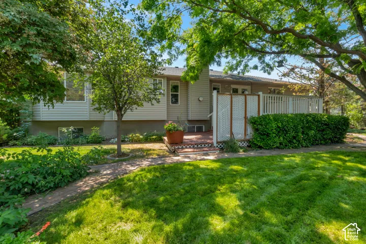 Expansive backyard featuring a lush lawn and established trees