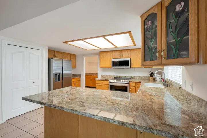 Spacious kitchen featuring an expansive island with a polished stone countertop