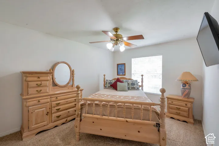 Carpeted room with a ceiling fan light fixture