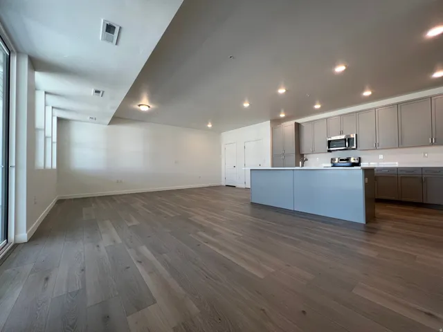 Open-concept living space featuring wood-finish flooring, recessed lighting, and a modern kitchen