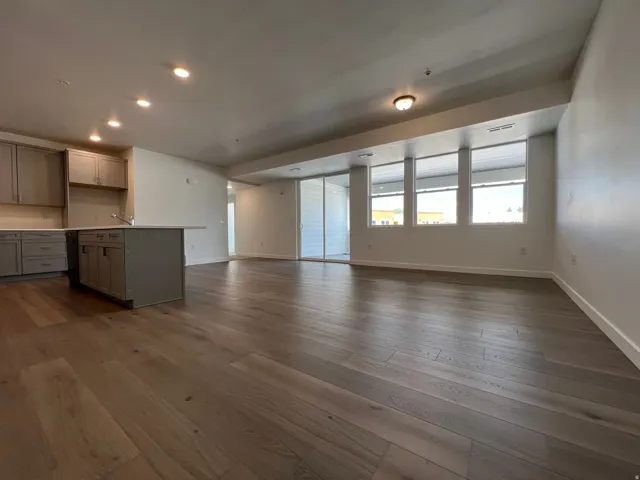 Open-concept living space with wide-plank wood-finish flooring and recessed lighting