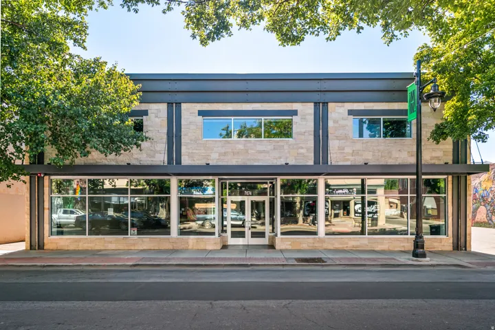 Commercial building with a stone-finish facade and prominent storefront windows