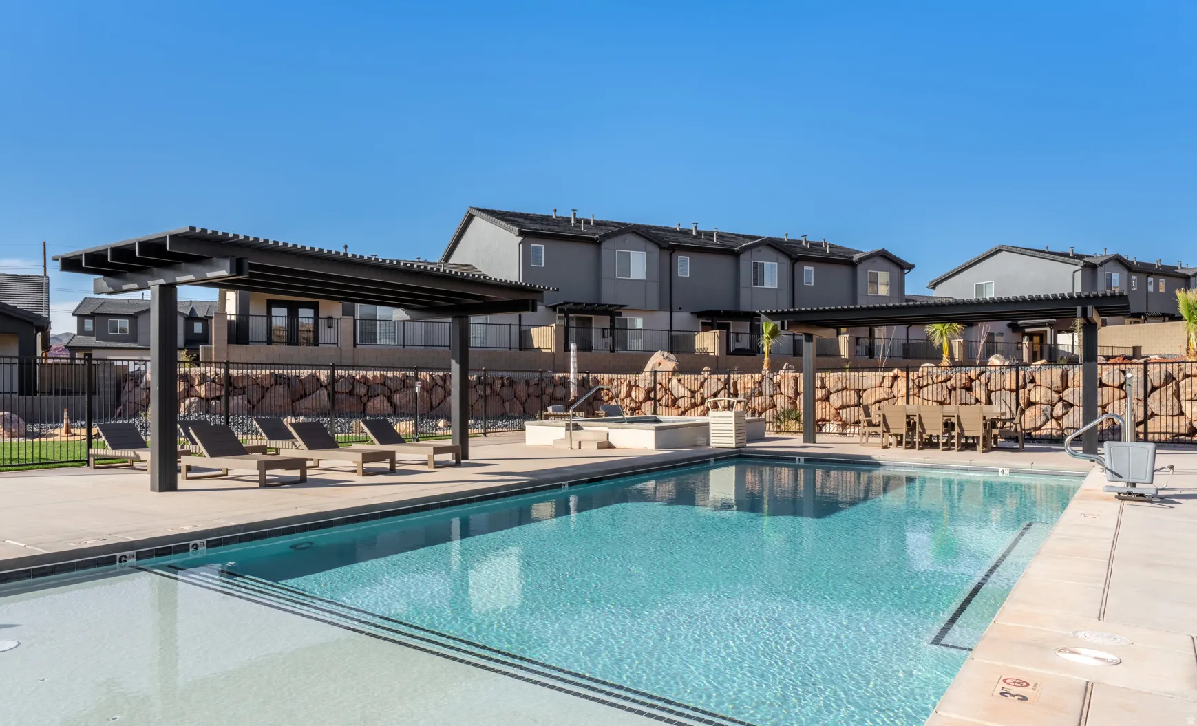 Resort-style swimming pool with integrated spa and concrete deck