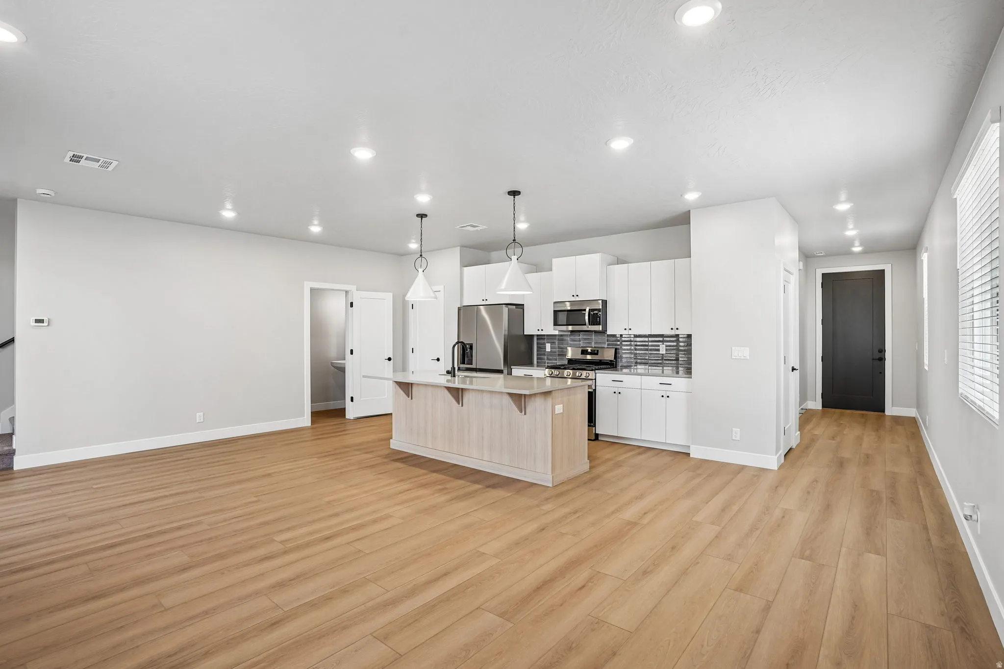 Open-concept living space with wood-finish flooring