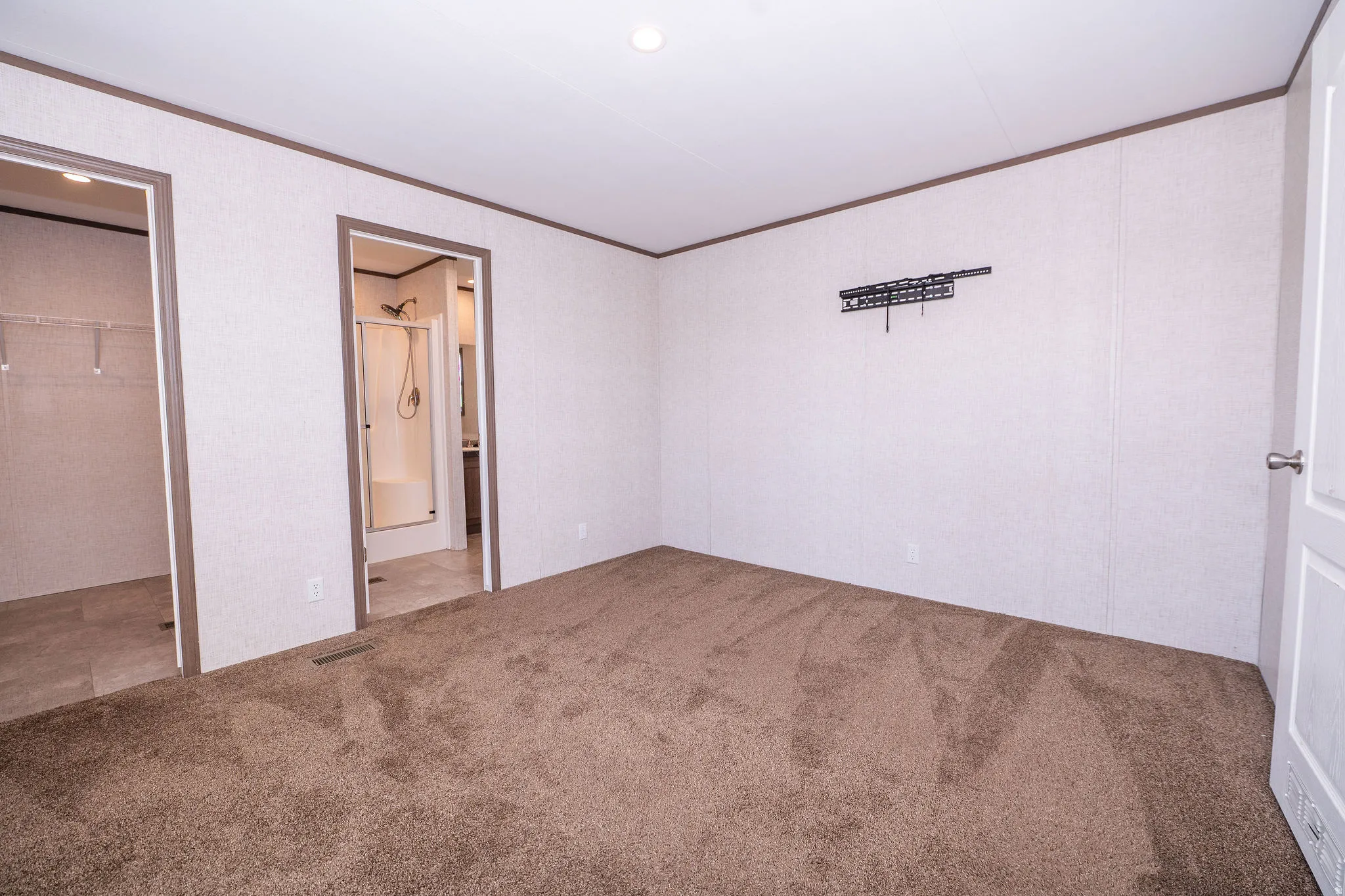 Spacious room with plush brown carpeting and white walls