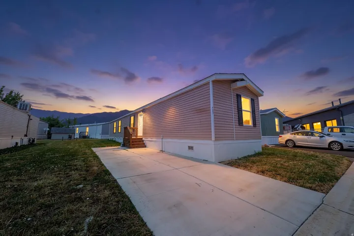 Home exterior featuring horizontal siding, a private concrete driveway, and a white foundation skirting