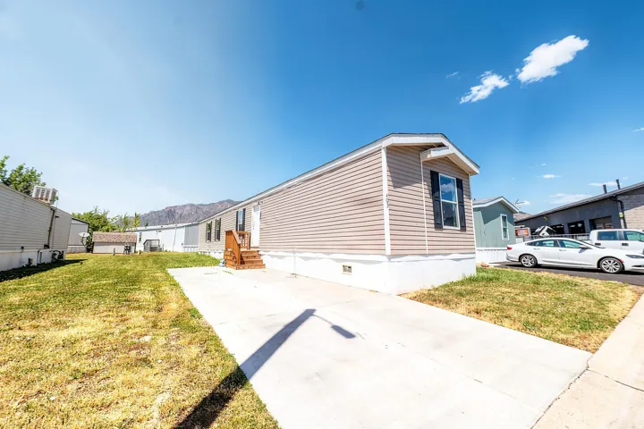 Light tan horizontal siding exterior with white trim and dark window shutters