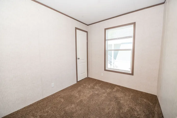 Neutral-toned walls featuring a textured finish, brown trim, and plush brown carpeting