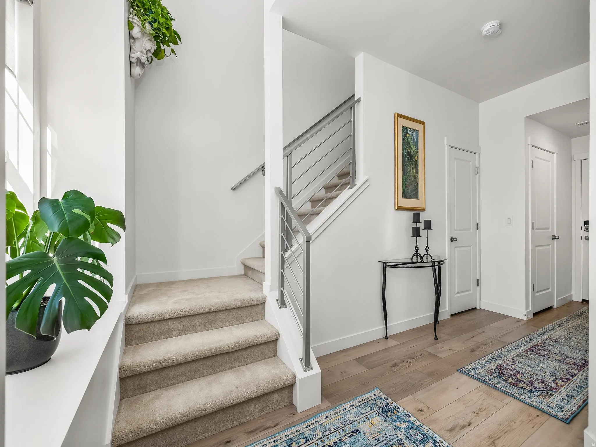 Entryway featuring wood-finish flooring and a carpeted staircase with a modern railing