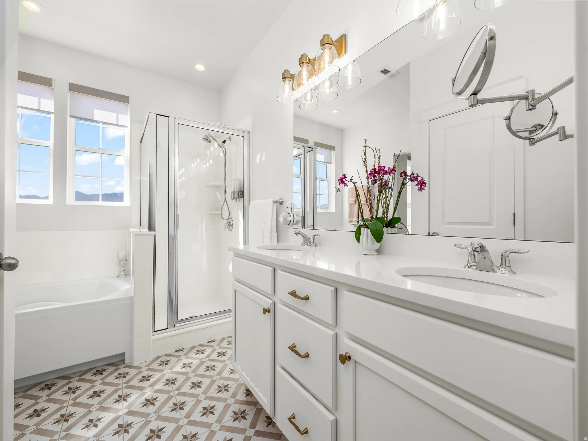 Bathroom featuring patterned tile flooring and a dual vanity with white cabinetry