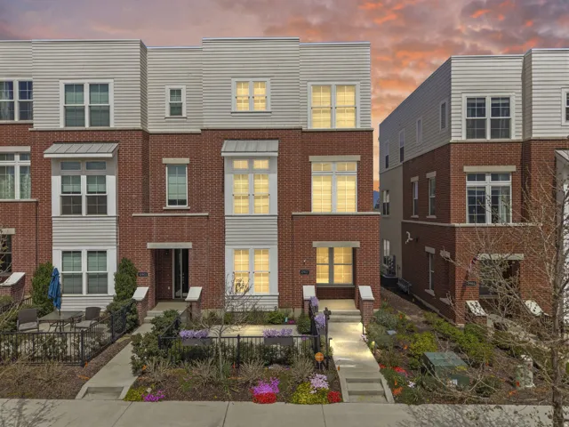 Brick and siding townhouse exterior featuring multiple windows and a private front patio