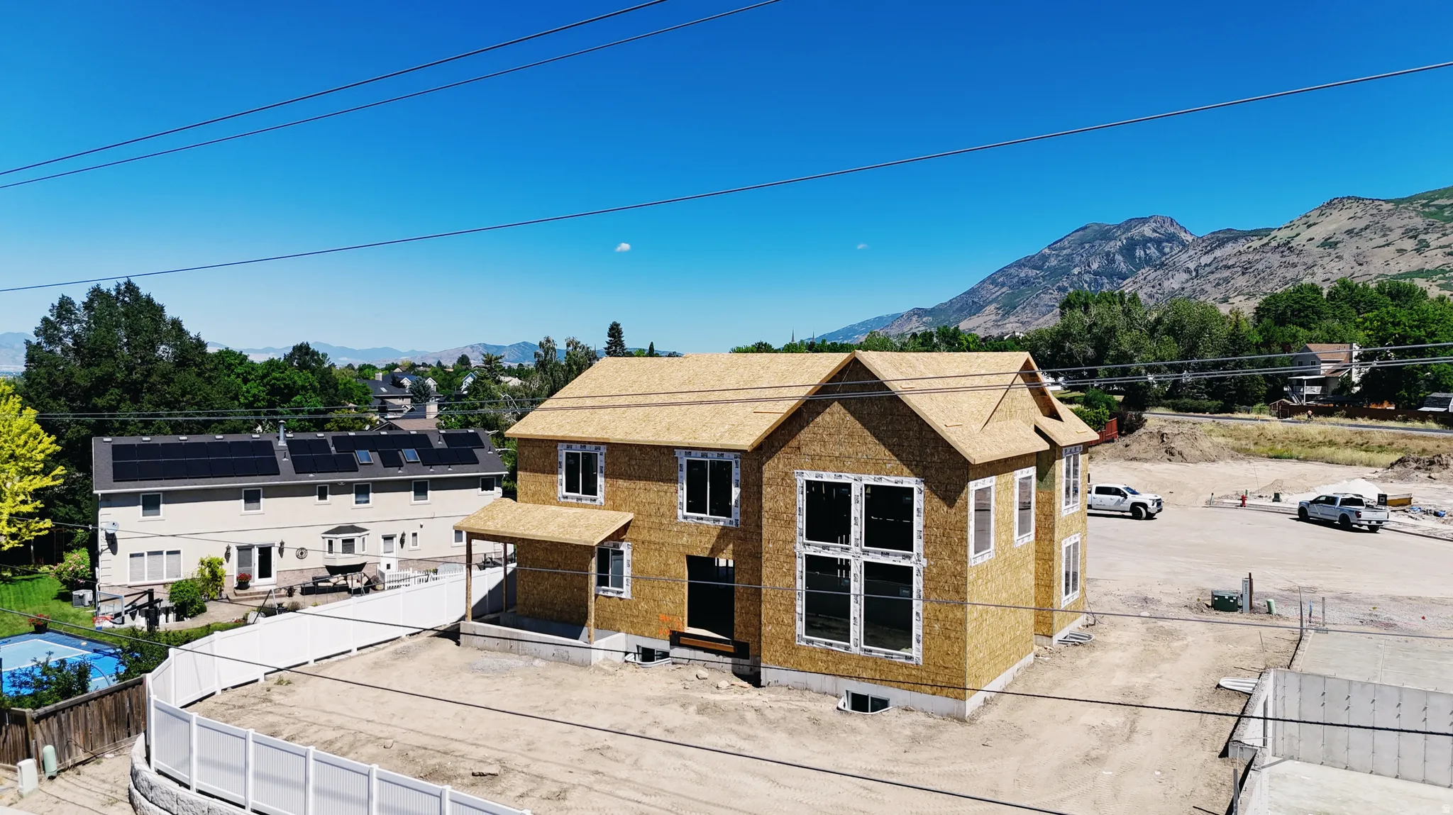 New construction residence featuring a two-story design with a basement, an attached covered entry, multiple window configurations, and a prominent mountain backdrop
