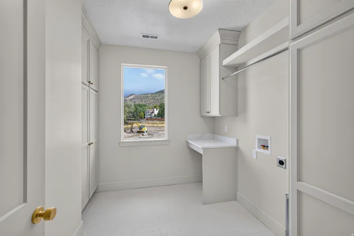 Built-in cabinetry providing storage, a countertop workspace, white tile flooring, and an overhead clothes rod
