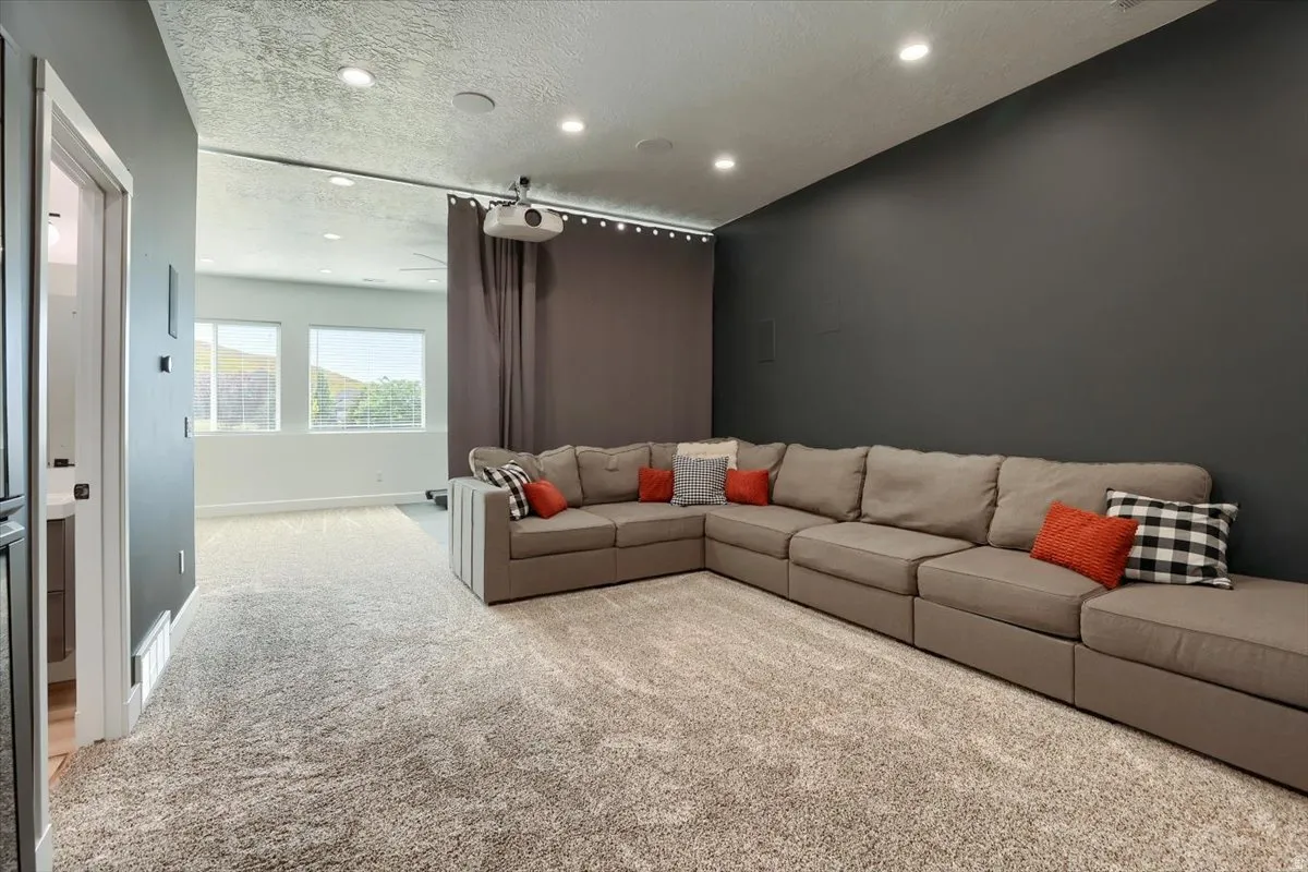 Media room featuring a projector, recessed lighting, and a large projection wall