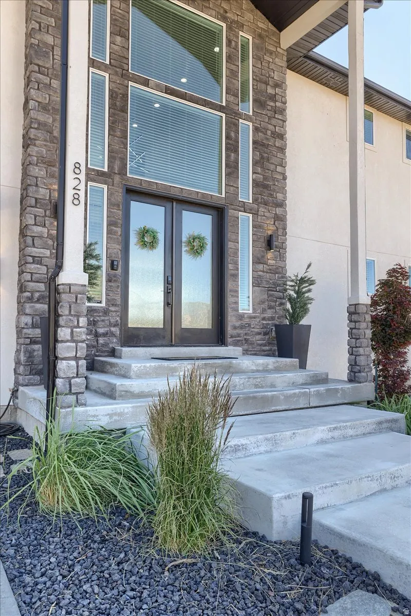 Stone veneer facade with prominent double-door entry and multi-pane windows