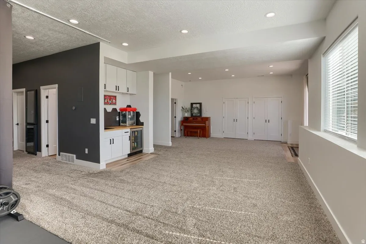 Lower-level recreation space featuring recessed lighting and neutral carpeting