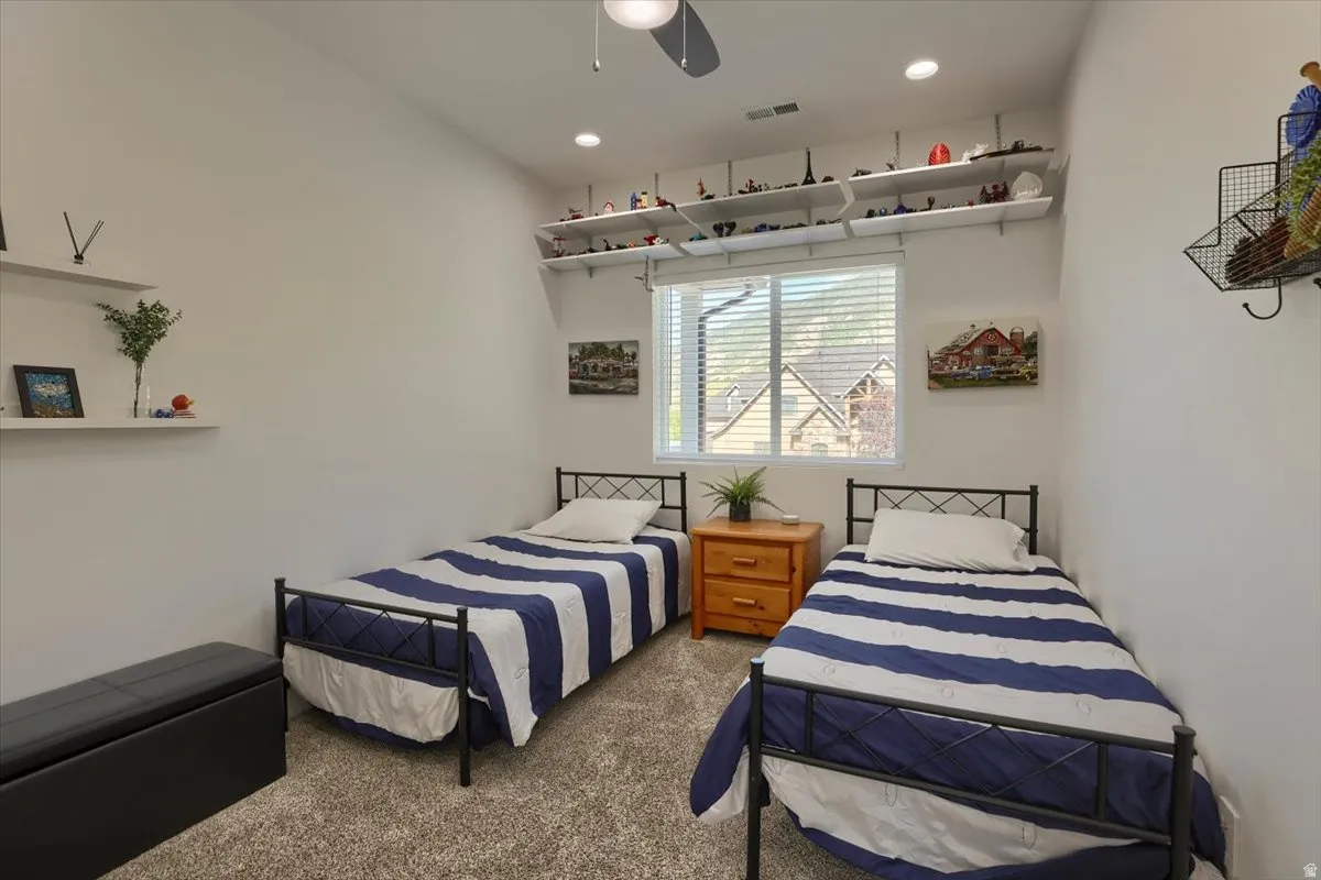 Carpeted room featuring a ceiling fan, recessed lighting, and a window with blinds