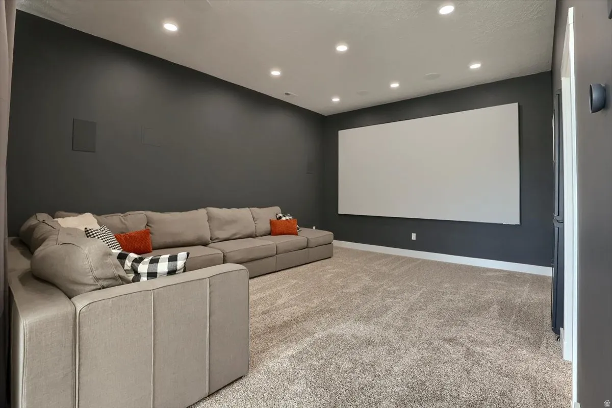 Dedicated media room featuring a large projection screen and dark accent walls