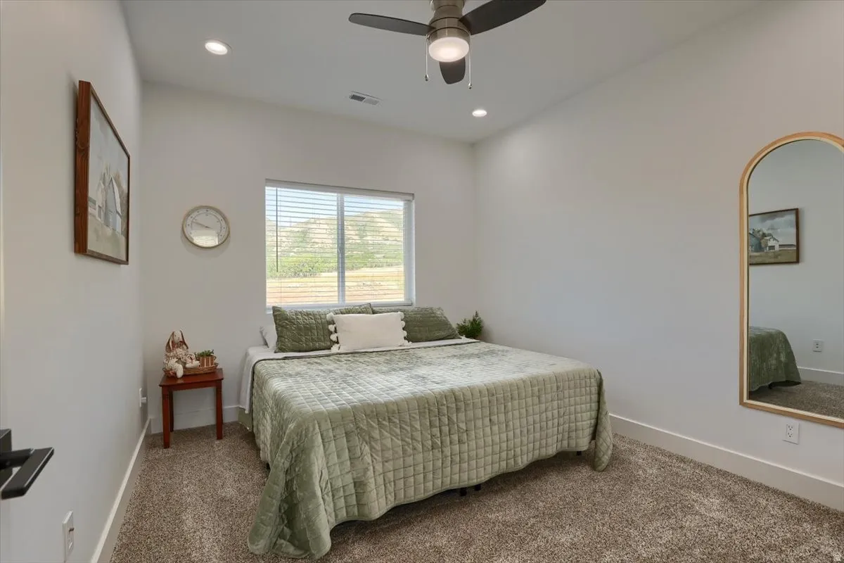 Bedroom featuring a ceiling fan with integrated lighting, recessed lighting, and a window with horizontal blinds