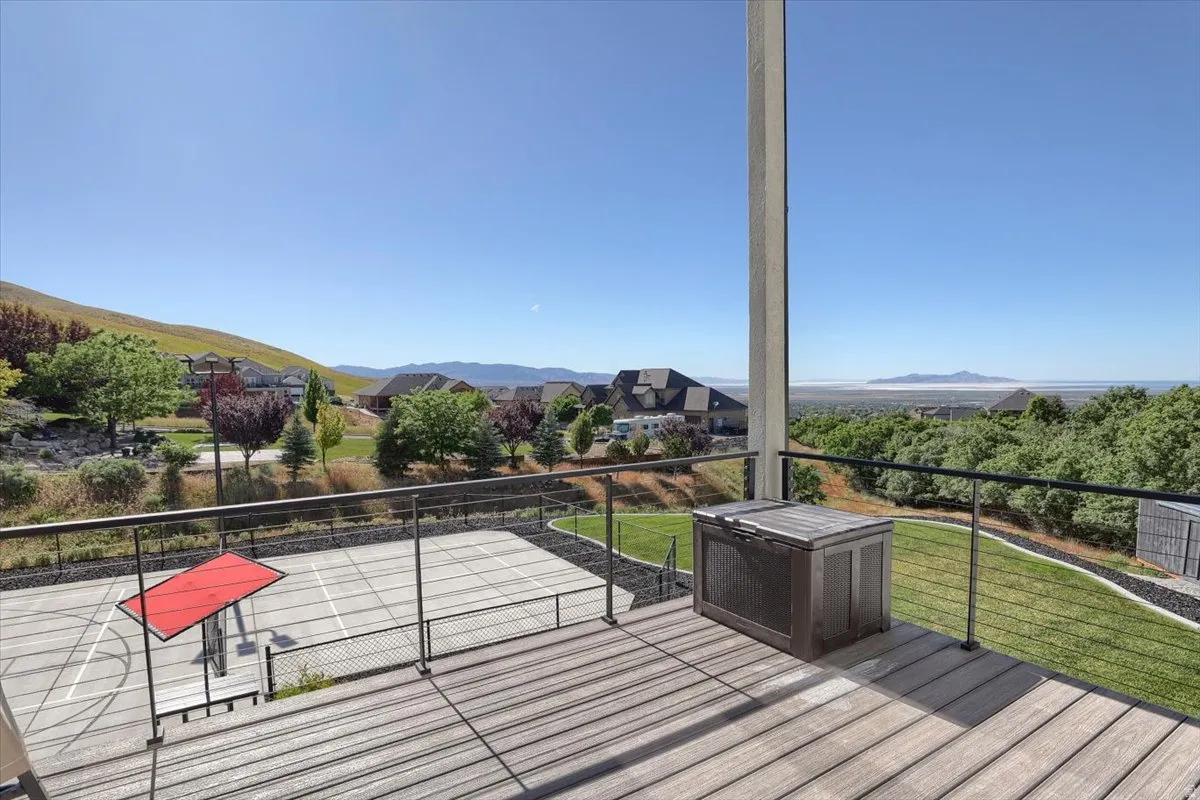 Expansive exterior deck featuring wood-finish flooring and a cable railing system
