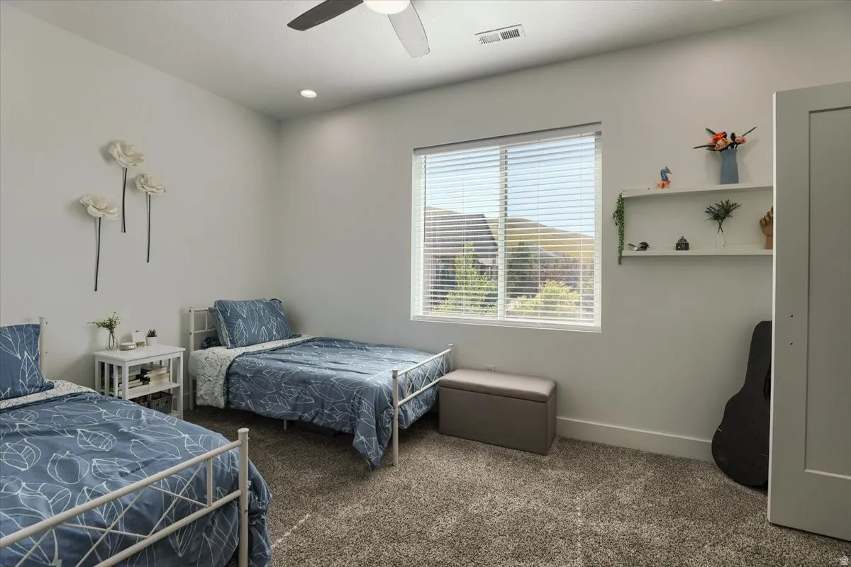 Bright room featuring a window with horizontal blinds, neutral wall paint, and textured carpet flooring