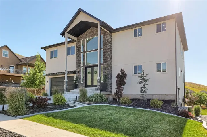 Contemporary two-story residence featuring a stone and stucco facade