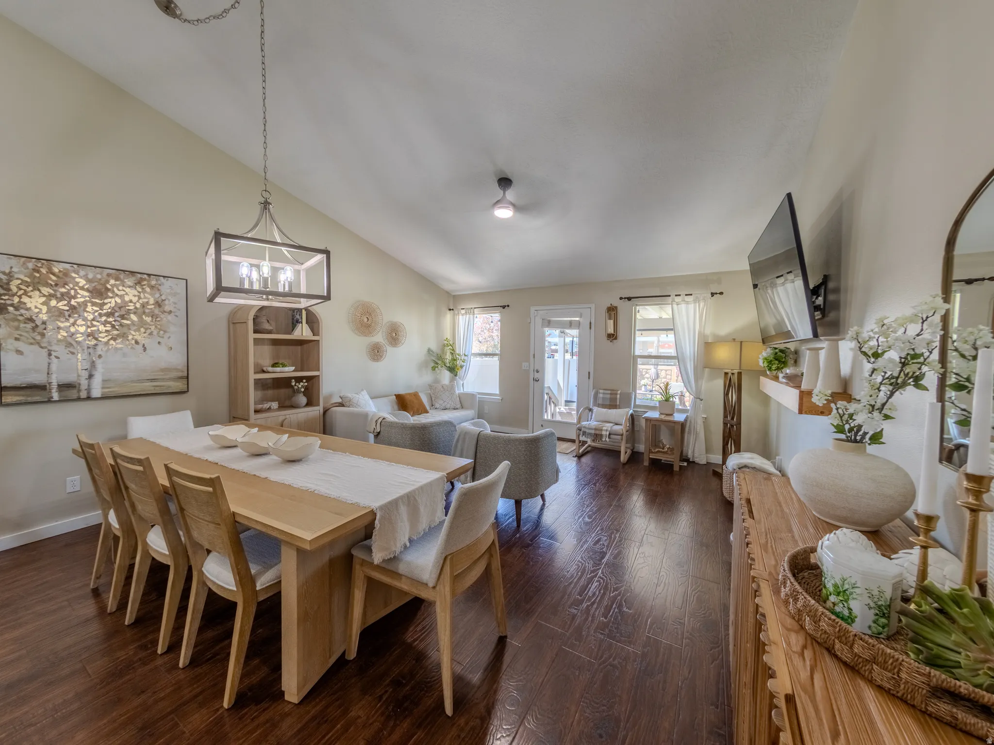 Vaulted ceilings above an open-concept living area with dark wood-finish flooring