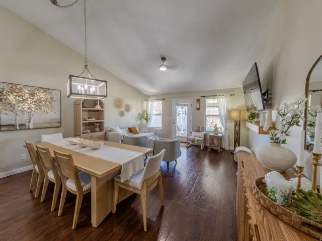 Vaulted ceilings above an open-concept living area with dark wood-finish flooring