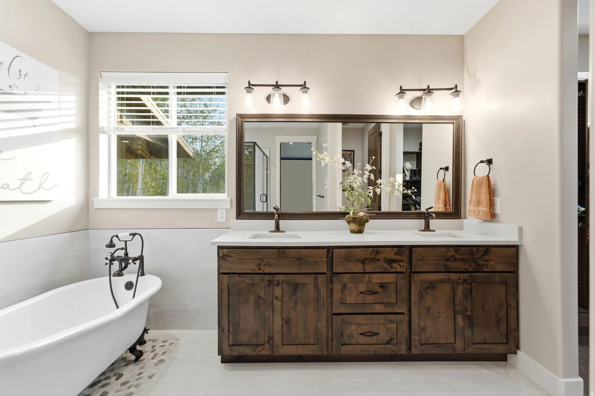 Bathroom featuring a dual-sink vanity with dark wood cabinetry and white countertops