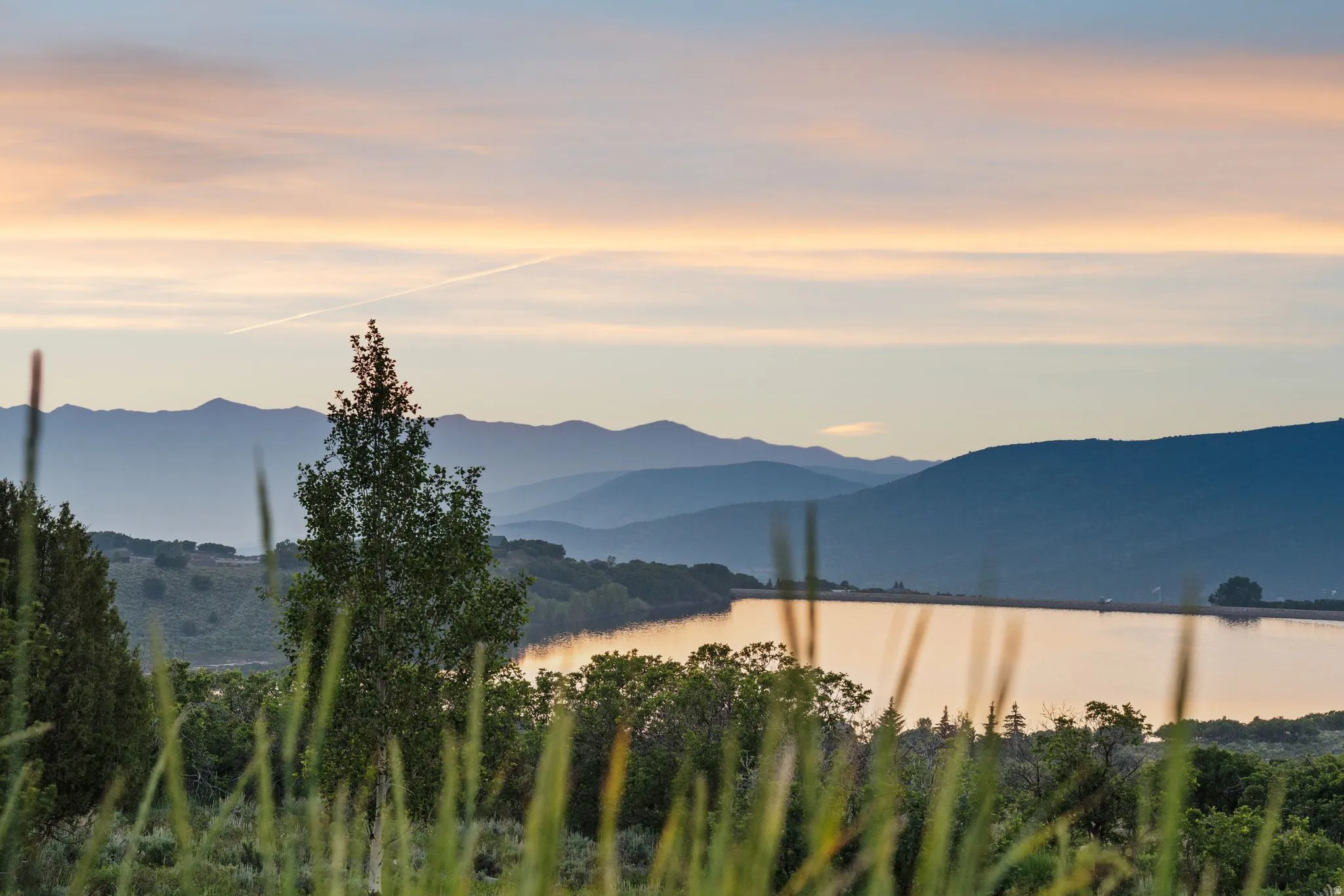 Expansive water feature bordered by distant mountain ranges and a variegated sky