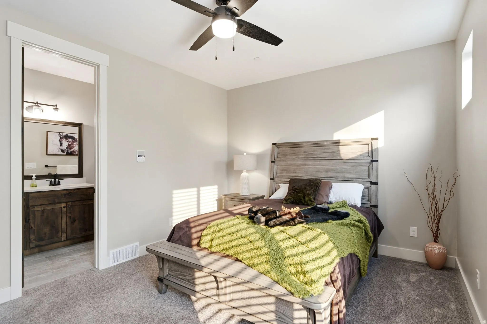 Carpeted bedroom featuring a ceiling fan, light-toned walls, and a window