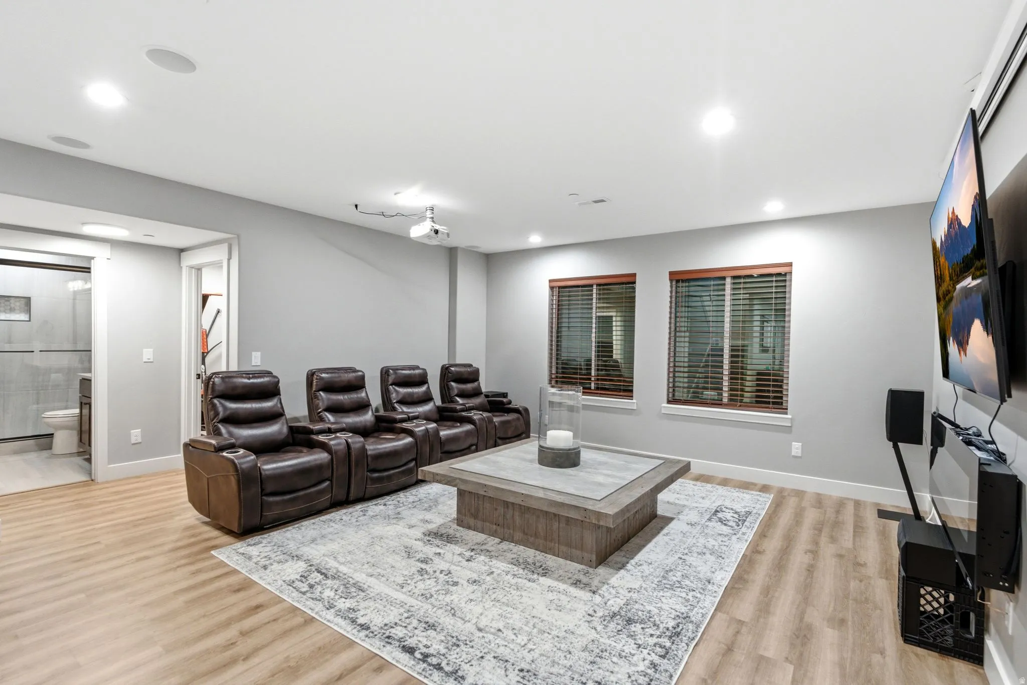 Dedicated entertainment room featuring recessed lighting, light wood-finish flooring, and built-in ceiling speakers