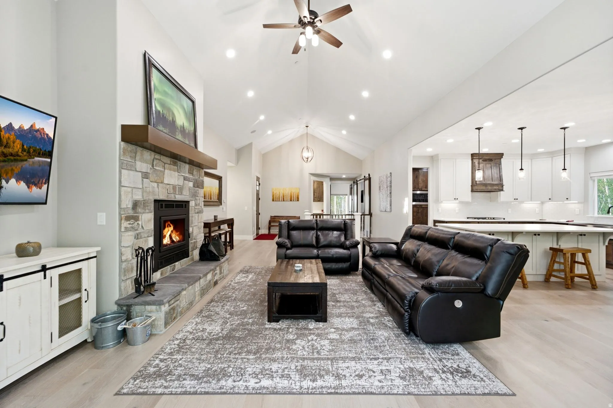 Spacious living area featuring vaulted ceilings, recessed lighting, and wood-finish flooring