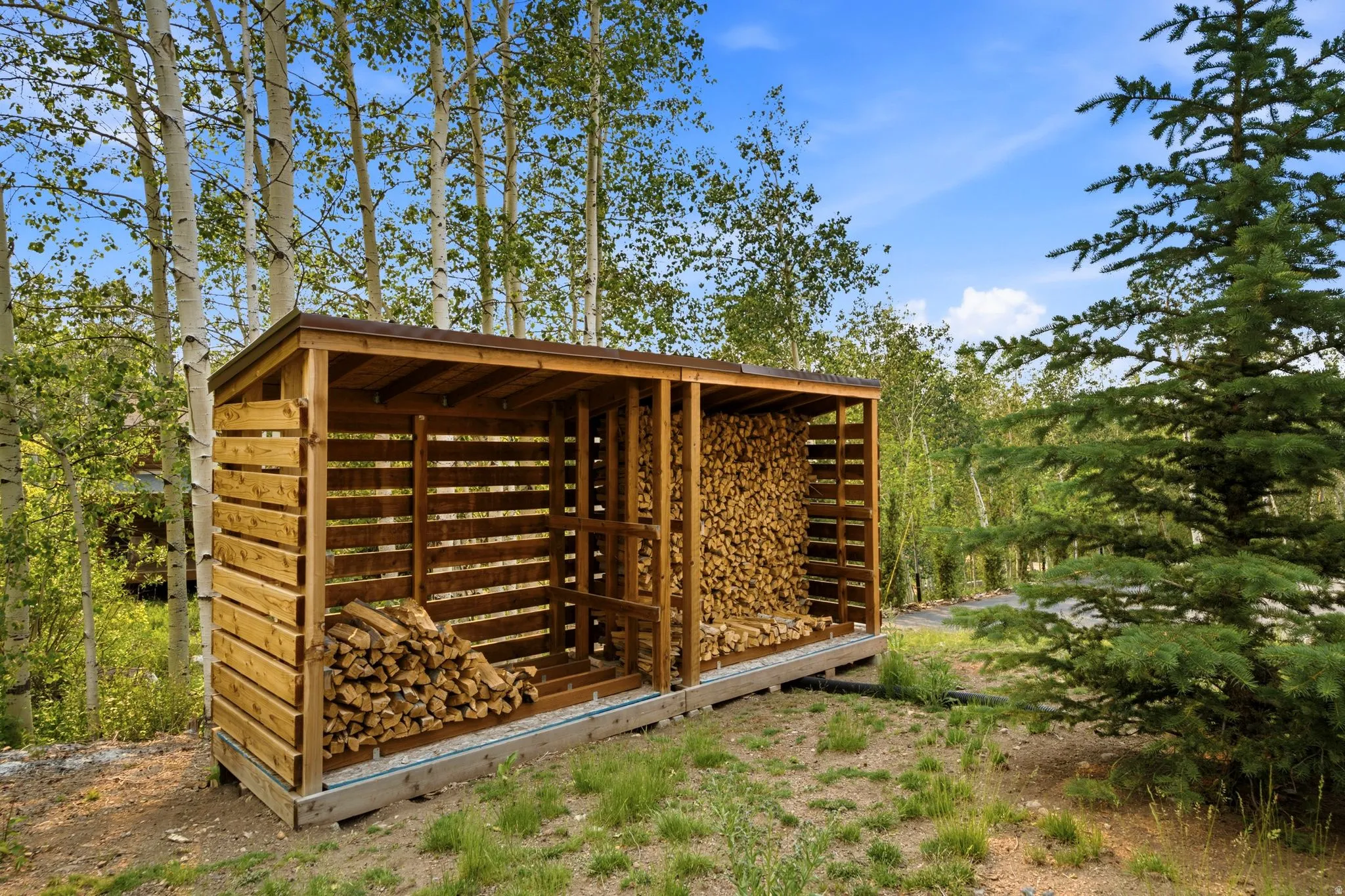 Wood-sided outdoor storage structure with a sloped roof and multiple storage bays